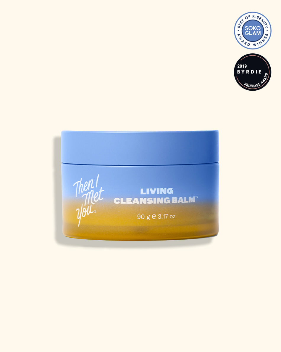 Yellow and blue jar of Living Cleansing Balm with white and gold lettering on beige background.